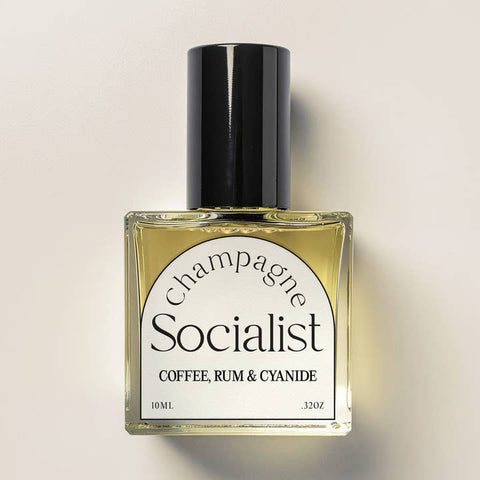 Bottle of 'Champagne Socialist' perfume with a black cap on a beige background