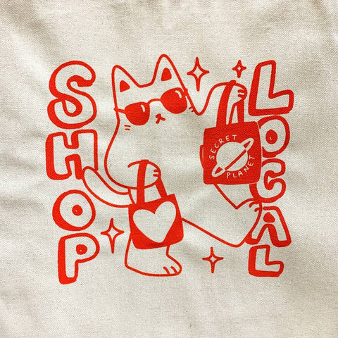 Red illustration of a cat with sunglasses and text on a beige background