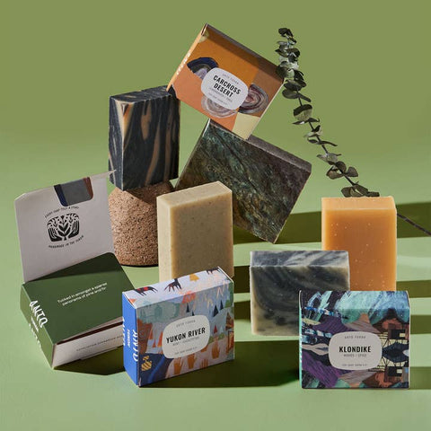 Collection of various soaps and packaging on a green background