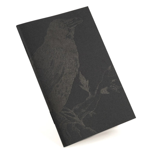 black notebook with charcoal raven