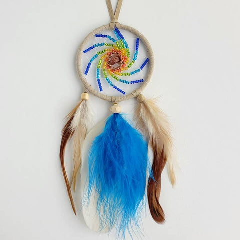Dreamcatcher with colorful beads and feathers on a white background
