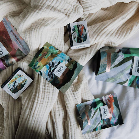 Colorful bath soak packages on a textured fabric surface