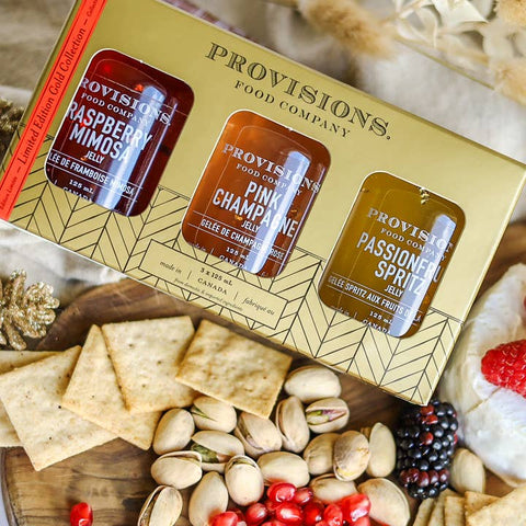 Provisions Food Company jelly gift set with crackers, nuts, and berries on a wooden board.