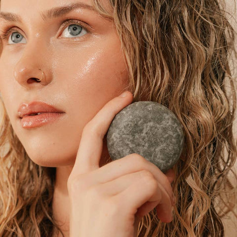 Woman applying a juju shampoo bar product to her hair