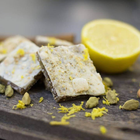 Squares of a dessert with lemon zest and cardamom on a wooden surface