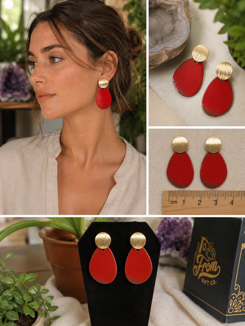 Woman wearing red teardrop earrings with gold tops, displayed with packaging and a ruler for scale.