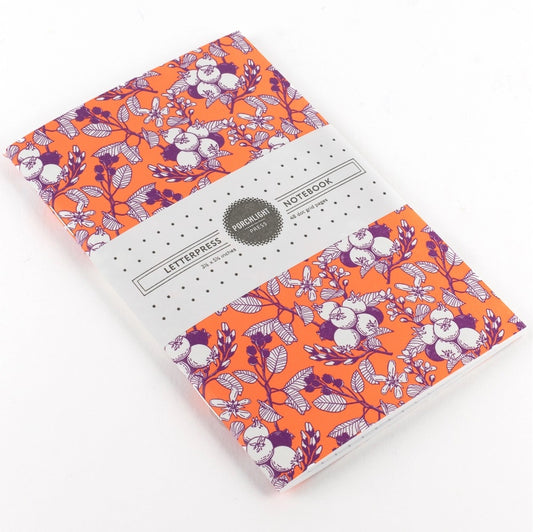 orange mini notebook with saskatoon berries